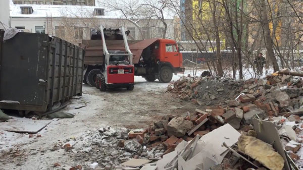 погрузчик загружает мусор